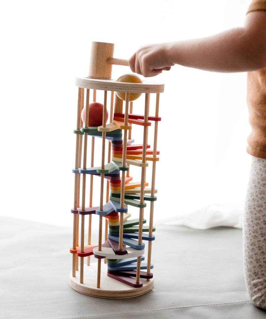 Rainbow-coloured, wooden toy Pound a Ball Tower. 