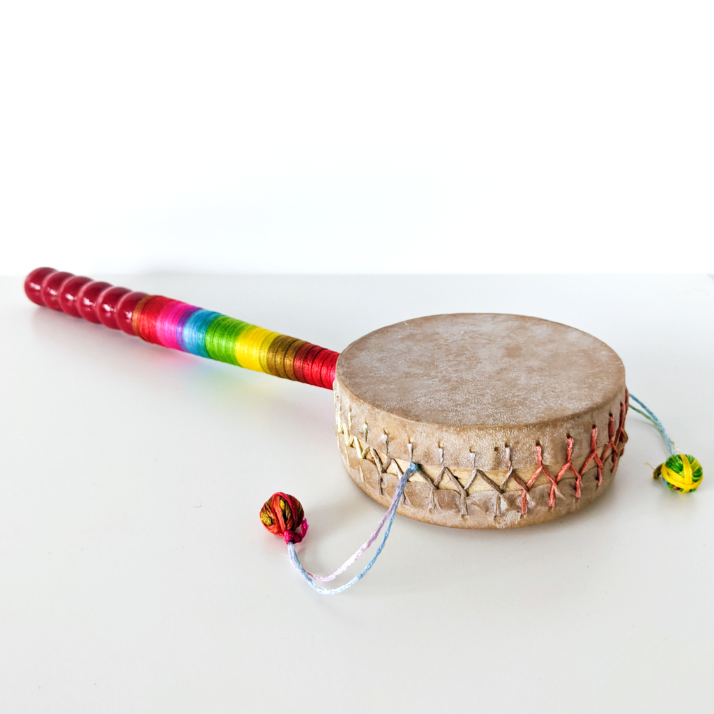 kids hand drum with a brightly rainbow-coloured handle
