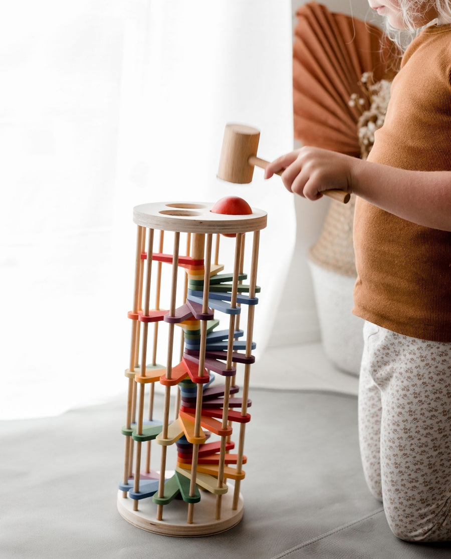 Rainbow-coloured, wooden toy Pound a Ball Tower. 