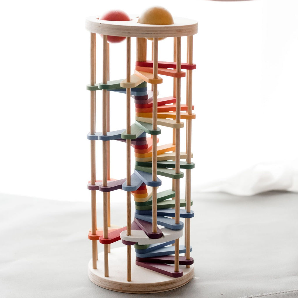 Rainbow-coloured, wooden toy Pound a Ball Tower. 